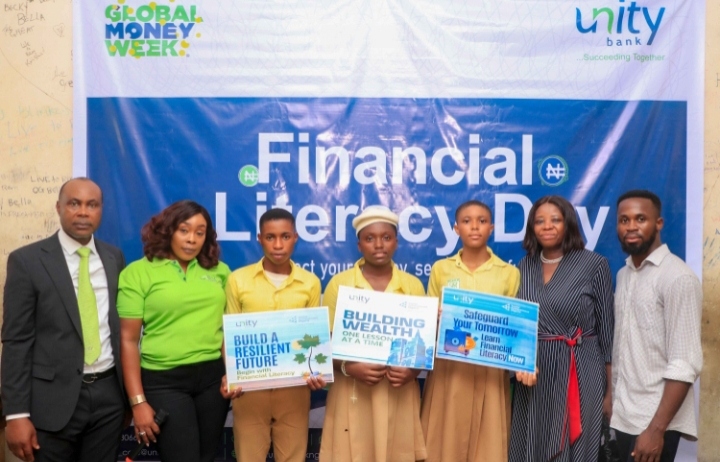 Some members of Unity Bank staff pose for a shot with some of the students and staff of NYSC Demonstration Secondary School, Calabar after the financial literary day training